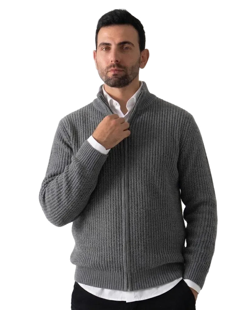 A man wearing a gray ribbed knit zip-up sweater over a white collared shirt, standing against a plain light background.