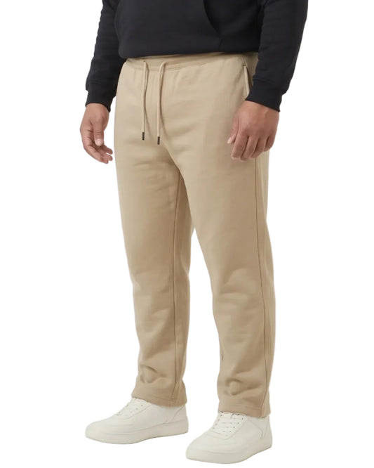 A man wearing a black pullover hoodie with 'FREEDOM' printed in white and blue on the chest, paired with beige drawstring sweatpants and white sneakers, photographed against a plain white studio background.