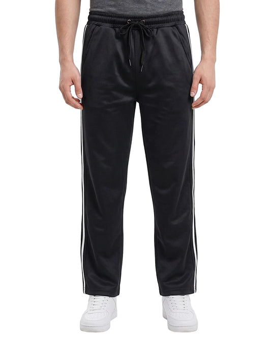 Person wearing black track pants with white stripes on a white background